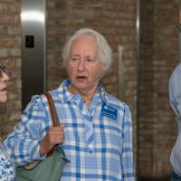 three people wearing blue chat in hallway